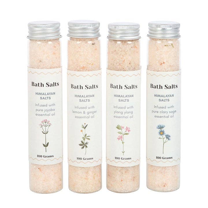 Set of four Himalayan bath salts in glass bottles with natural labels without box against white background
