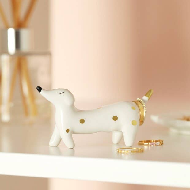 Dog-shaped jewellery stand holding multiple rings on its tail