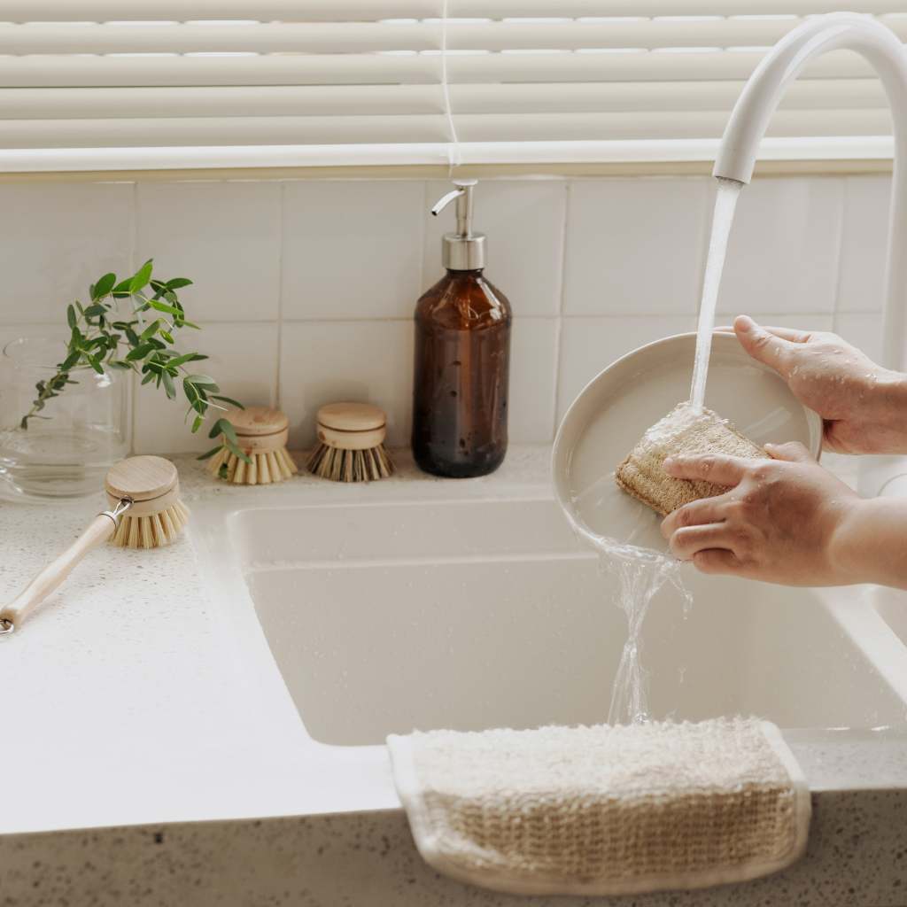 Bamboo kitchen brush set with long handle, refill heads and loofah on washing up in progress