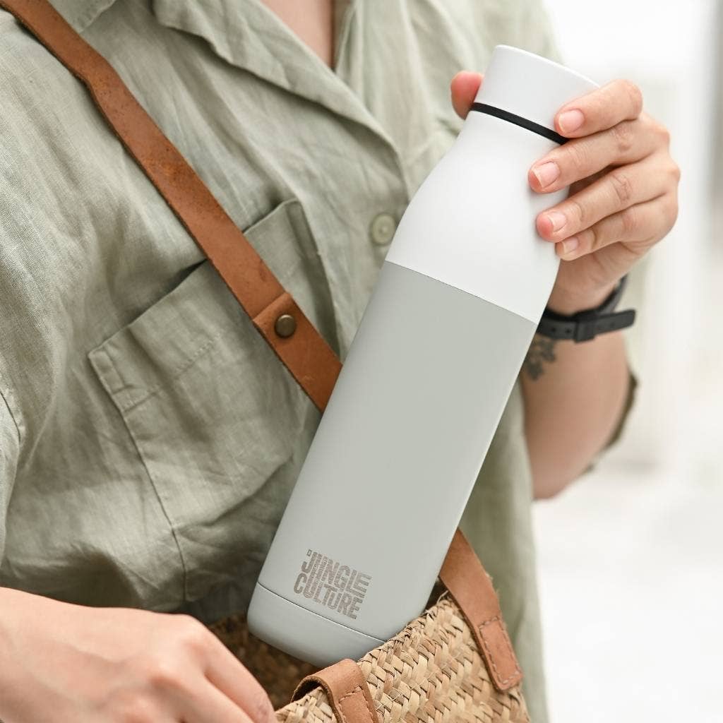 Insulated stainless steel water bottle being put into a work bag