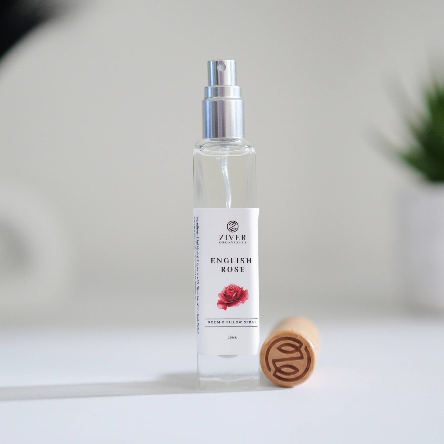 English Rose room spray in glass bottle on white linen with lid removed