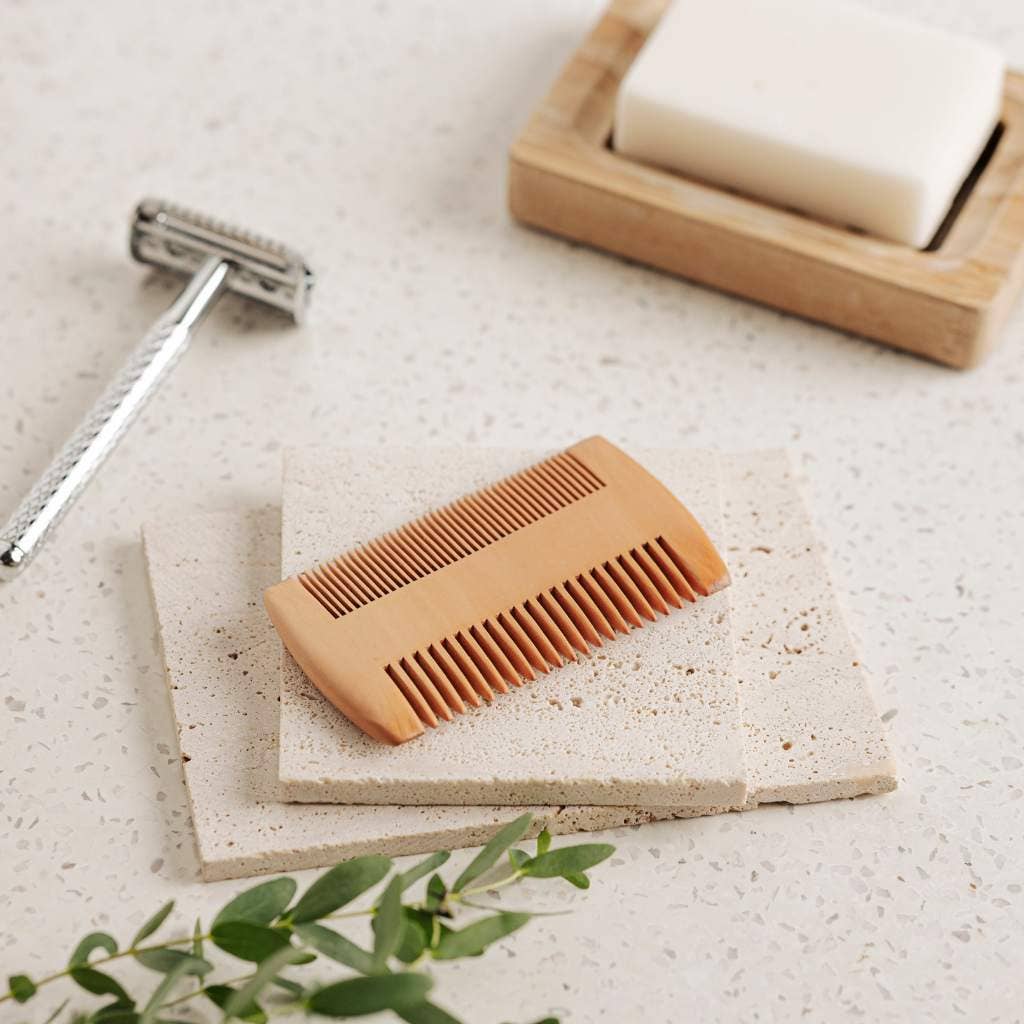 Close-up of fine teeth on beard comb with smooth wood grain finish