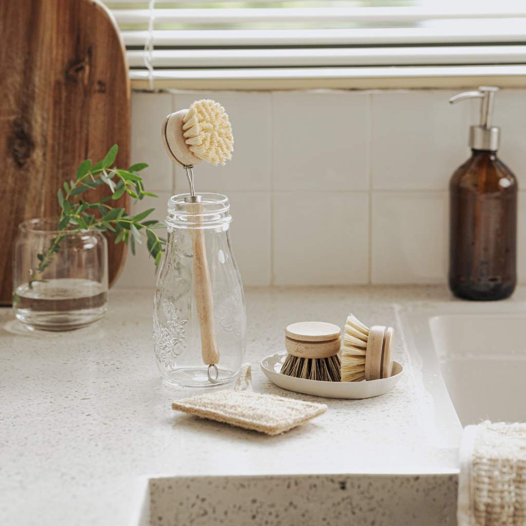 Bamboo kitchen brush set with long handle, refill heads and loofah on ceramic sink