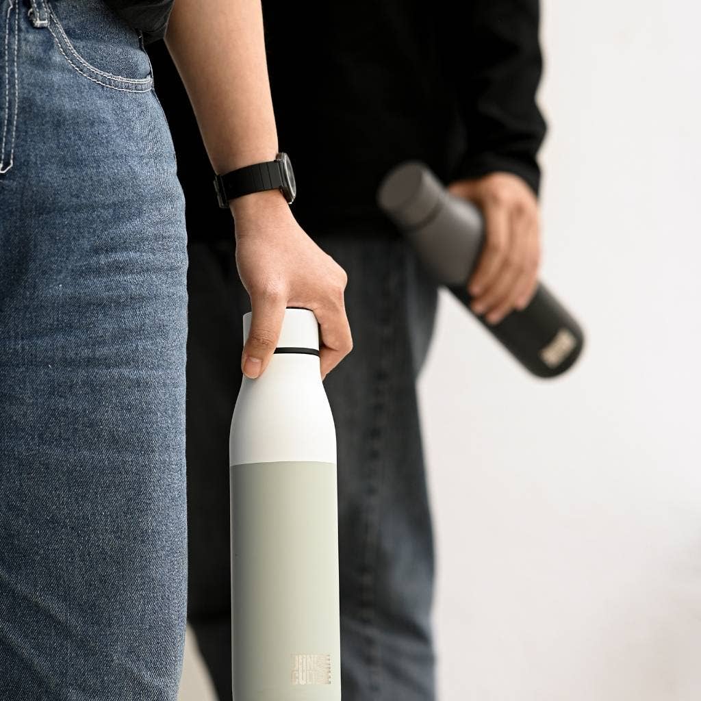 Insulated stainless steel water bottle held at waist height