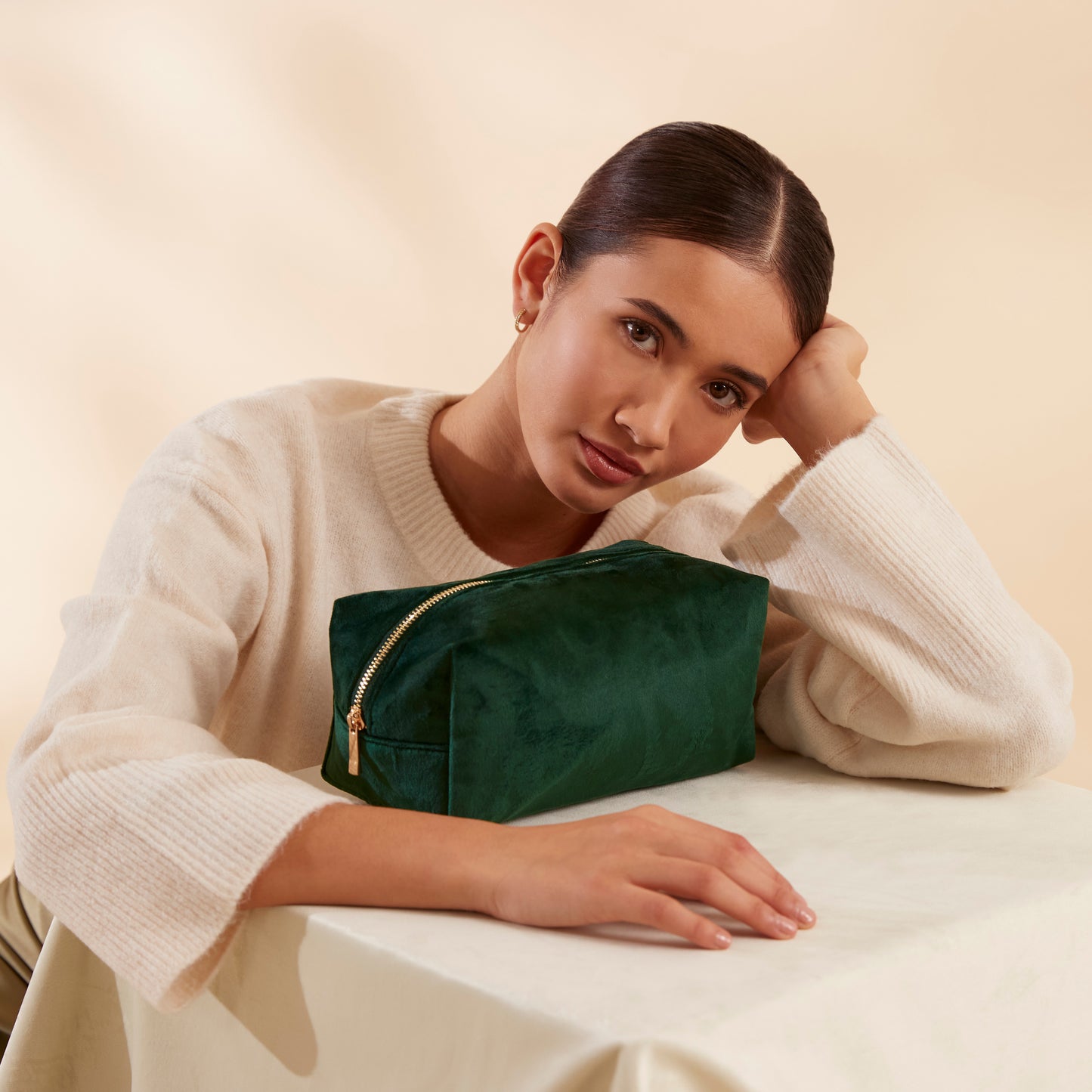 Lifestyle image velvet toiletry bag in rich colour with gold zip