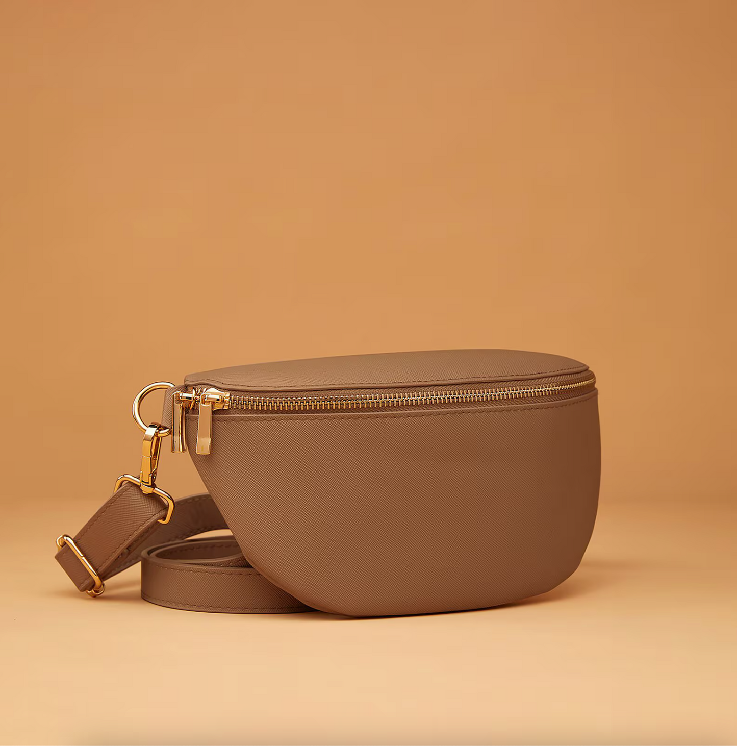 Flat lay of accessories with monogrammed bum bag in neutral tones