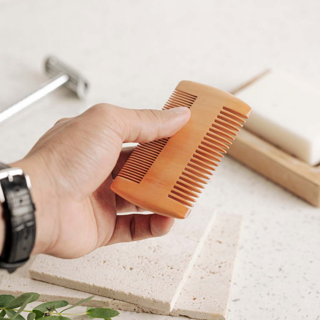 Close-up of fine teeth on beard comb with smooth wood grain finish