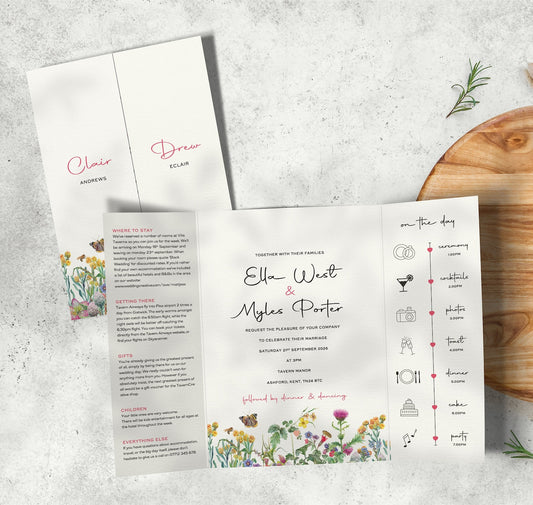 Colourful Spring Florals gatefold wedding invitation, showing a timeline panel, guest information and the main information. The invitation is set on a table next to props.