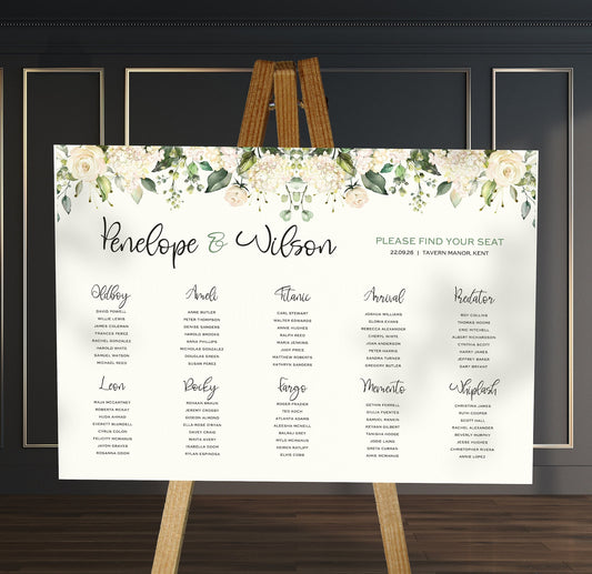 white and green florals wedding Table Plan on a brown easel in a stylish room in a wedding venue