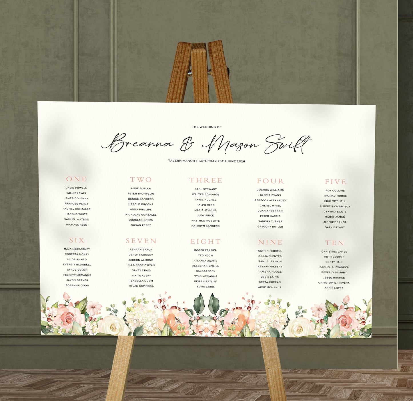 blush floral wedding Table Plan on a brown easel in a stylish room in a wedding venue