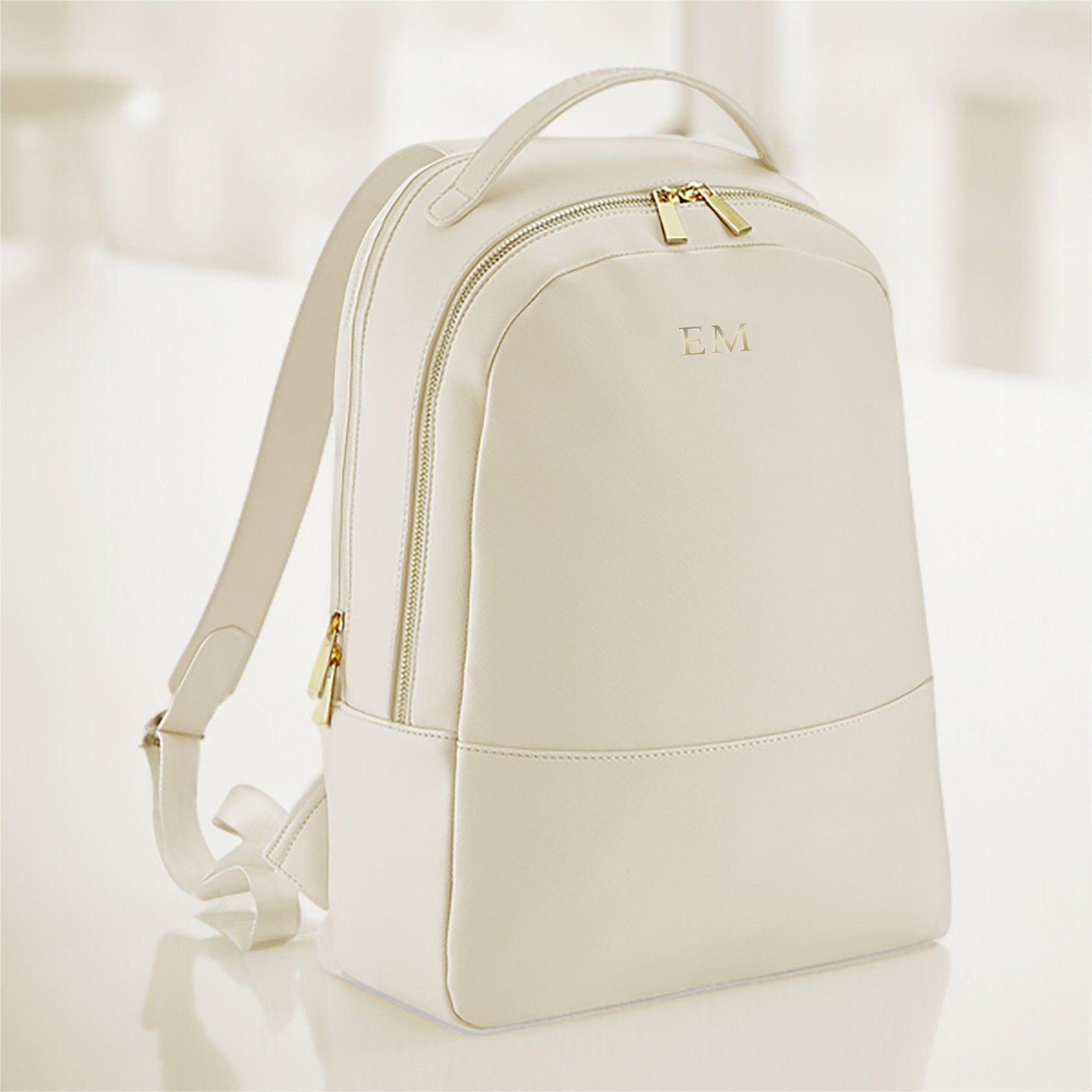 Modern oyster faux leather laptop backpack displayed on work desk