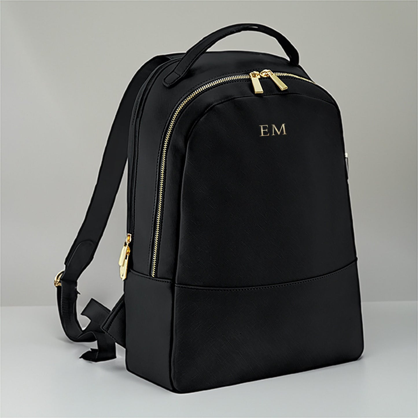 Personalised black backpack with metallic initials and gold hardware on faux Saffiano leather