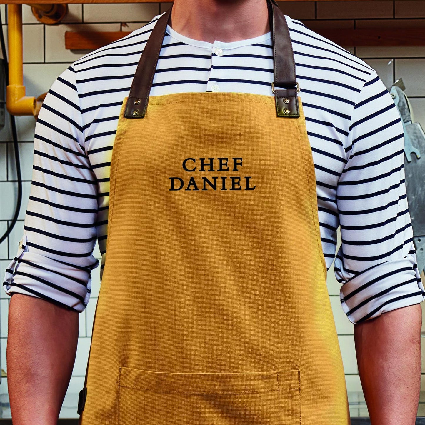 Personalised apron with black vinyl name on mustard cotton
