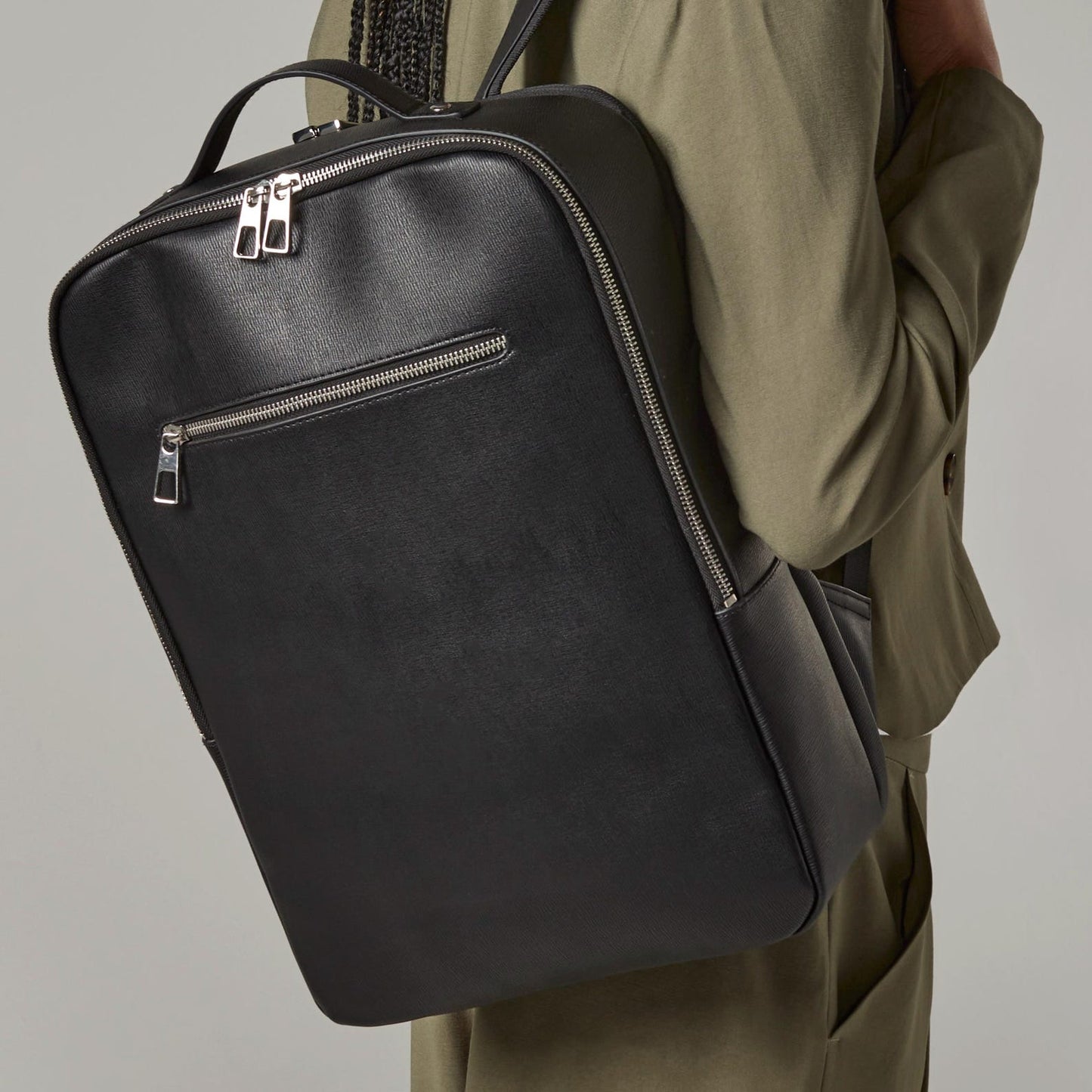Lifestyle Photo of Unisex personalised backpack with silver initials on leather-look finish