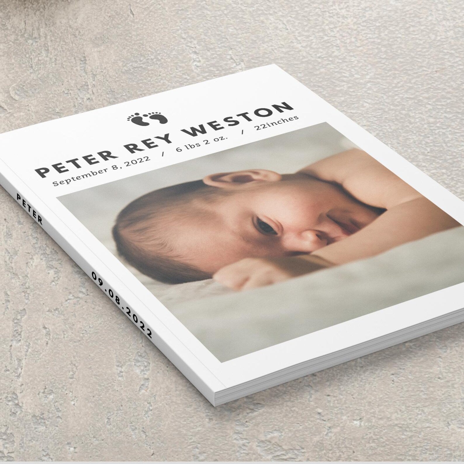 Hardcover personalised baby photo album closed on coffee table with baby photo displayed