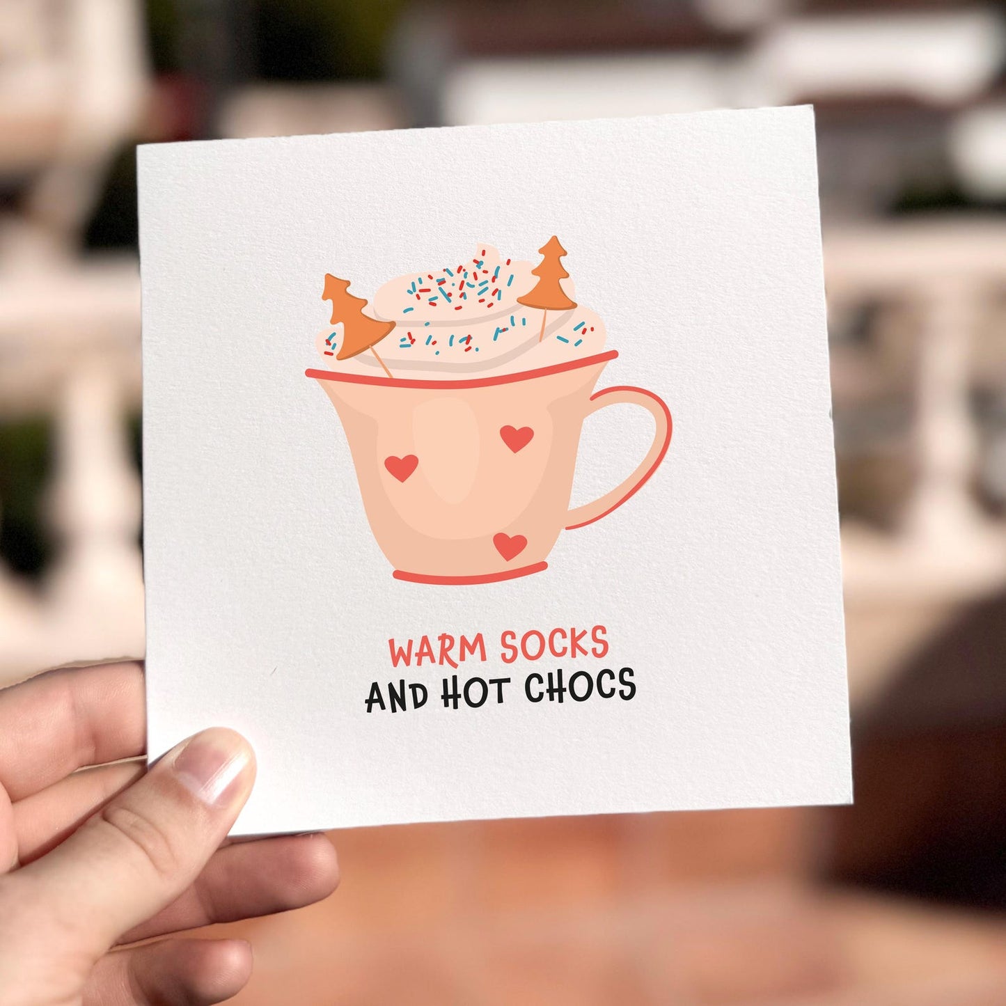 Cosy festive card featuring a mug of hot chocolate with the text ‘Warm Socks And Hot Chocs’.
