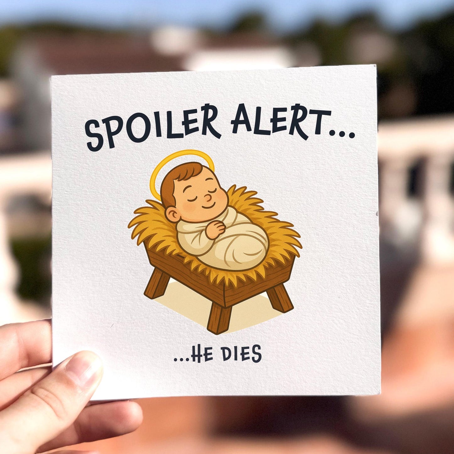 Funny Christmas card featuring baby Jesus in a manger with the text ‘Spoiler Alert… He Dies’.