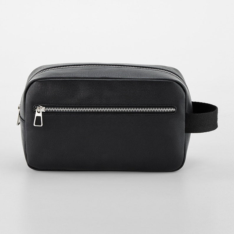 Close-up of silver monogram print on tailored PU leather wash bag