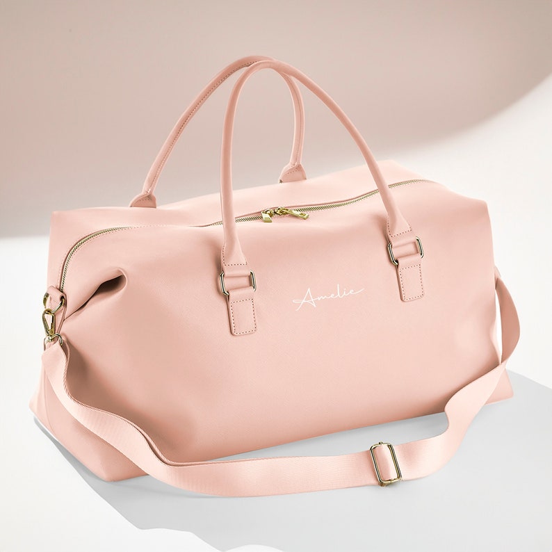 Side view of pink holdall with adjustable strap and structured base