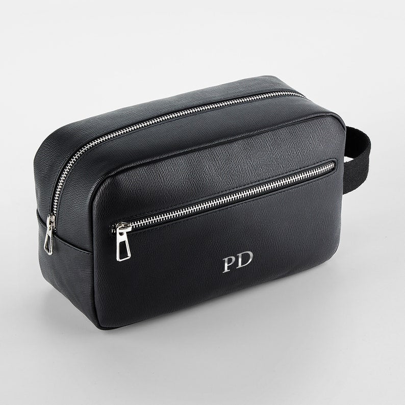 Close-up of silver monogram print on tailored PU leather wash bag