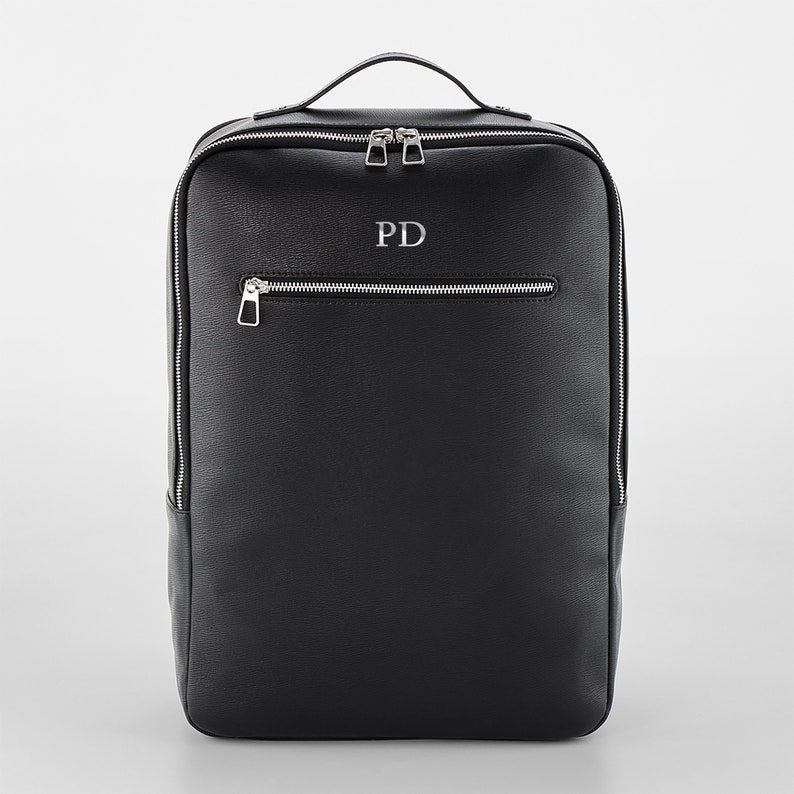Silver monogram close-up on black backpack – clean HTV finish