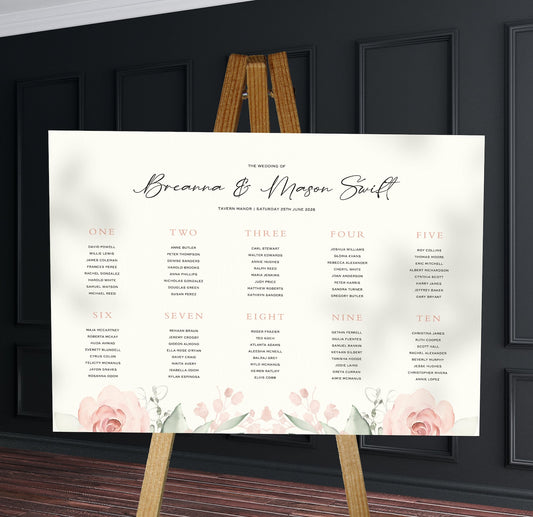 muted pink and blush florals wedding Table Plan on a brown easel in a stylish room in a wedding venue