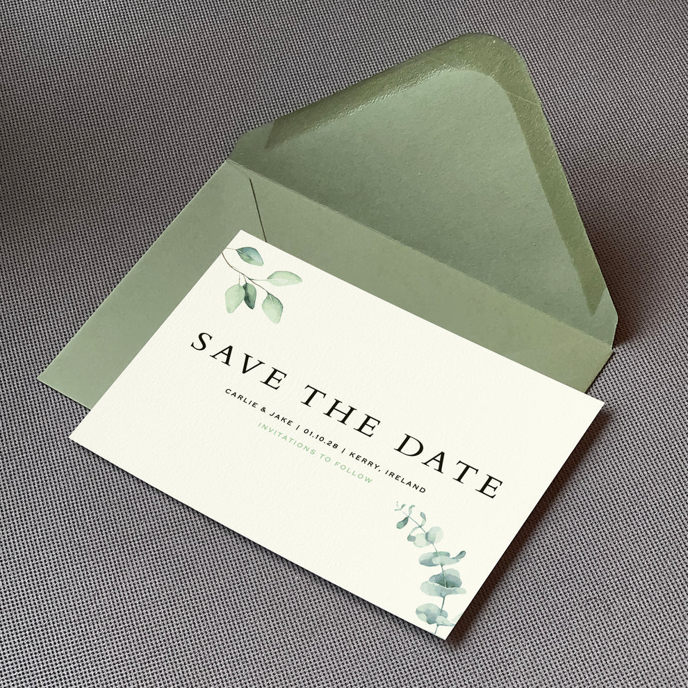 a save the date card sat on top of an envelope on a table