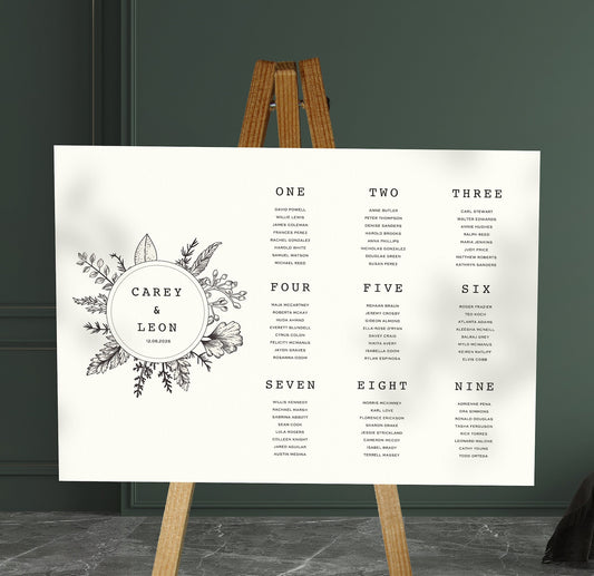 black and white floral sketch wedding Table Plan on a brown easel in a stylish room in a wedding venue