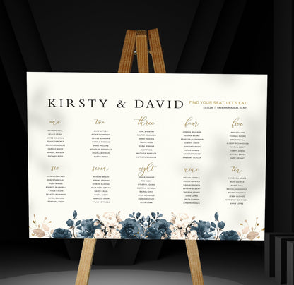 blue floral wedding Table Plan on a brown easel in a stylish room in a wedding venue