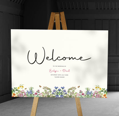 colourful spring florals A1 welcome sign board on a brown easel in a wedding venue room with stylish decor