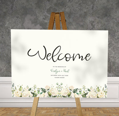 white and green florals A1 welcome sign board on a brown easel in a wedding venue room with stylish decor