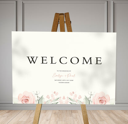 muted pink and sage florals A1 welcome sign board on a brown easel in a wedding venue room with stylish decor