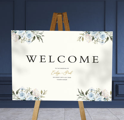 blue roses A1 welcome sign board on a brown easel in a wedding venue room with stylish decor