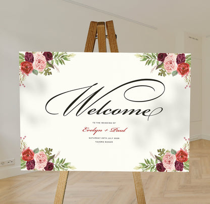 burgundy and blush floral A1 welcome sign board on a brown easel in a wedding venue room with stylish decor