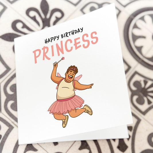 Funny birthday card showing a cartoon man dressed as a fairy princess holding a wand, with text ‘Happy Birthday Princess’.