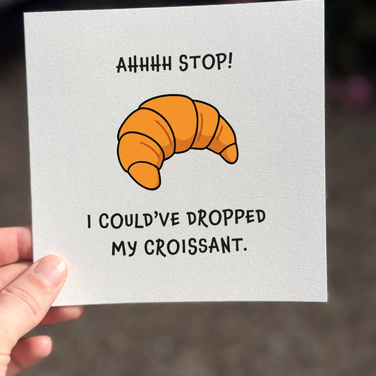 Funny meme card featuring an illustrated croissant with the quote ‘Ahhhh stop! I could’ve dropped my croissant’.