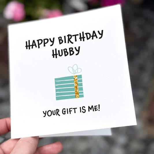 Funny birthday card showing a blue striped present and the text ‘Happy Birthday Hubby – Your gift is me!’.