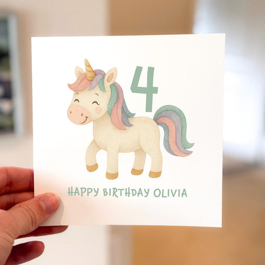 Pastel unicorn birthday card with rainbow mane and number 4, text reads ‘Happy Birthday’.
