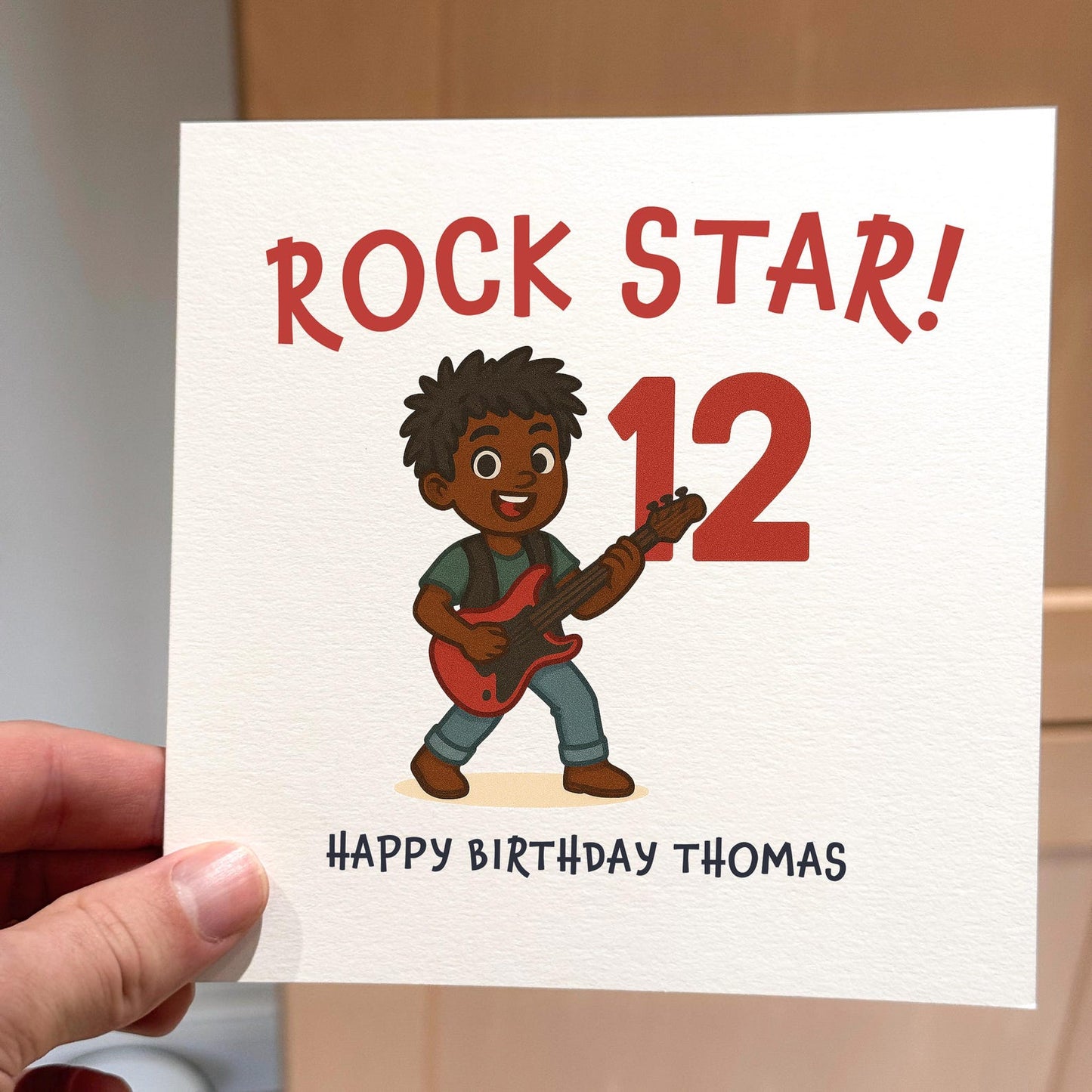 Birthday card featuring a cartoon child playing guitar with text ‘Rock Star! Happy Birthday’.