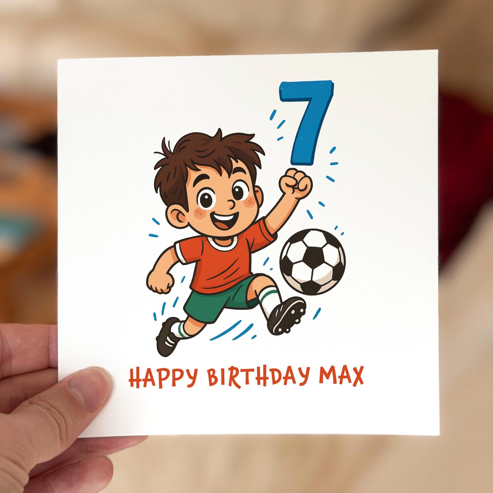 Birthday card featuring a cartoon boy in a red shirt kicking a football with a large blue number seven, printed on textured white card.