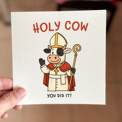 Funny congratulations card featuring a cartoon cow in bishop robes with the text ‘Holy Cow You Did It’.