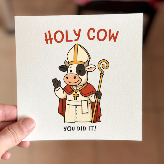 Funny congratulations card featuring a cartoon cow in bishop robes with the text ‘Holy Cow You Did It’.