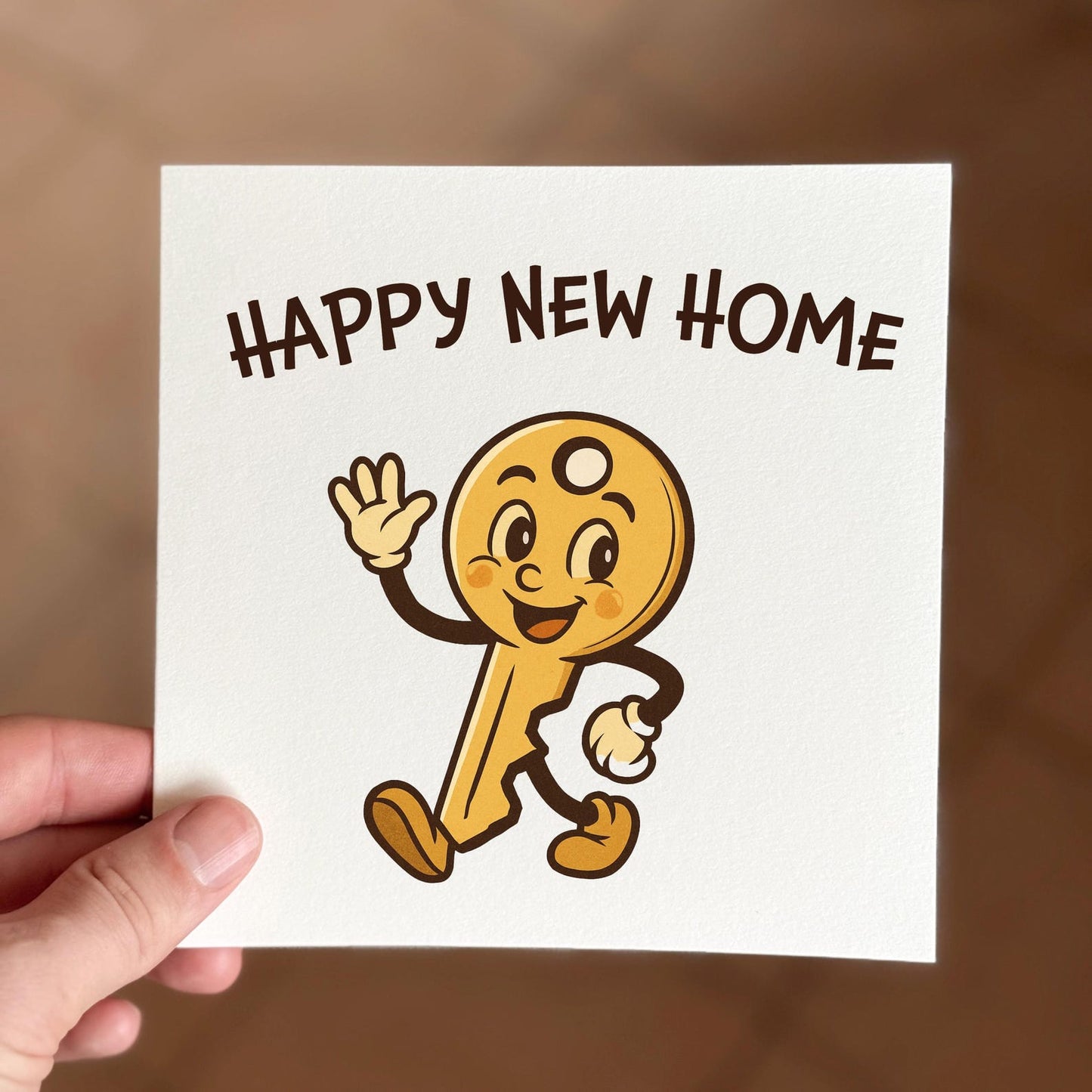 New home card featuring a smiling cartoon key character with the text ‘Happy New Home’.