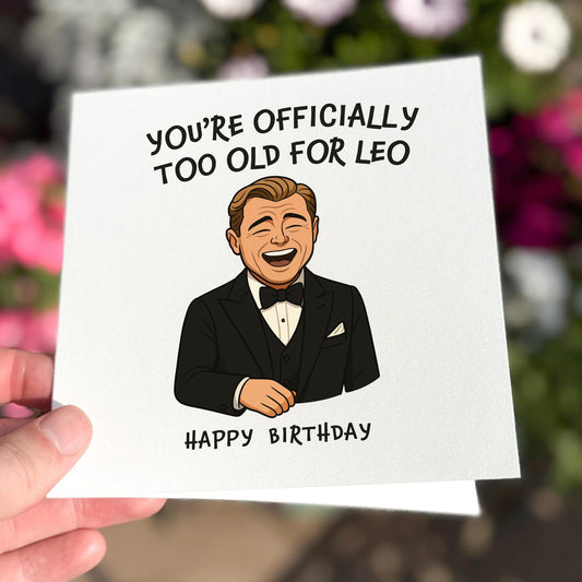 Funny birthday card showing a man in a tuxedo laughing with the text ‘You’re officially too old for Leo’.