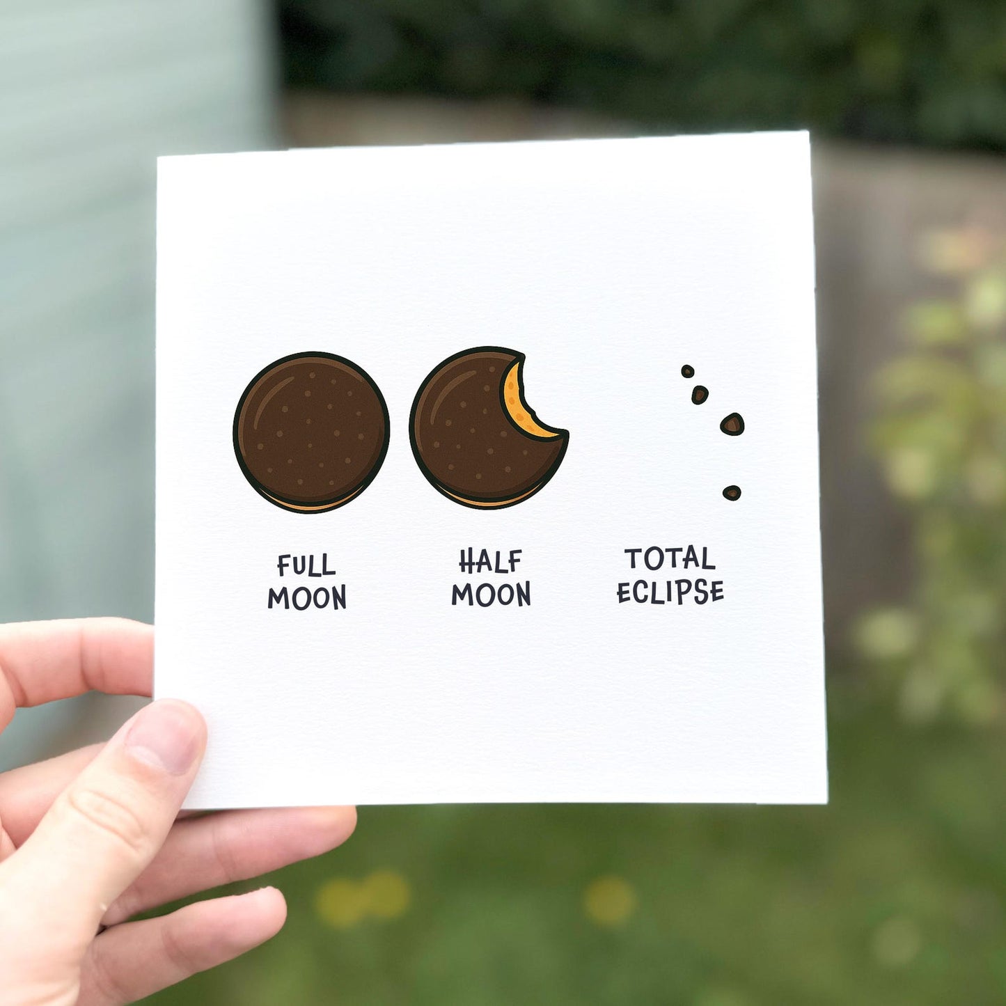 Funny card showing three chocolate biscuit illustrations labelled ‘Full moon’, ‘Half moon’, and ‘Total eclipse’.