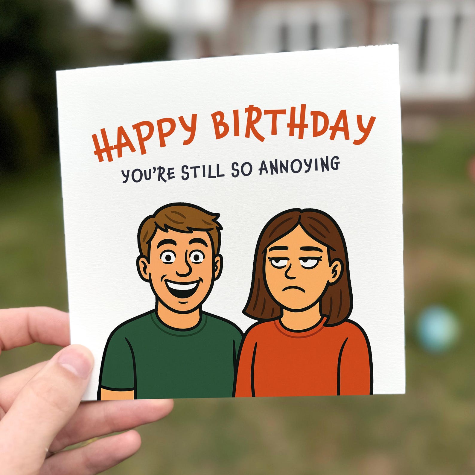 Funny cartoon birthday card showing a smiling man and unimpressed woman with the quote ‘You’re still so annoying’.