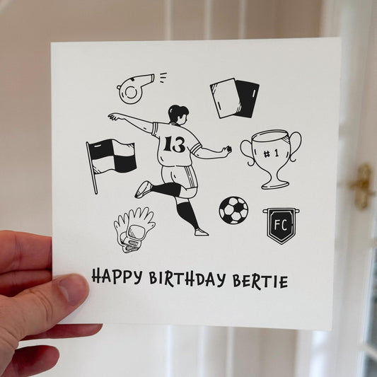 Birthday card showing a football player kicking a ball surrounded by trophies and football symbols, printed on white card.