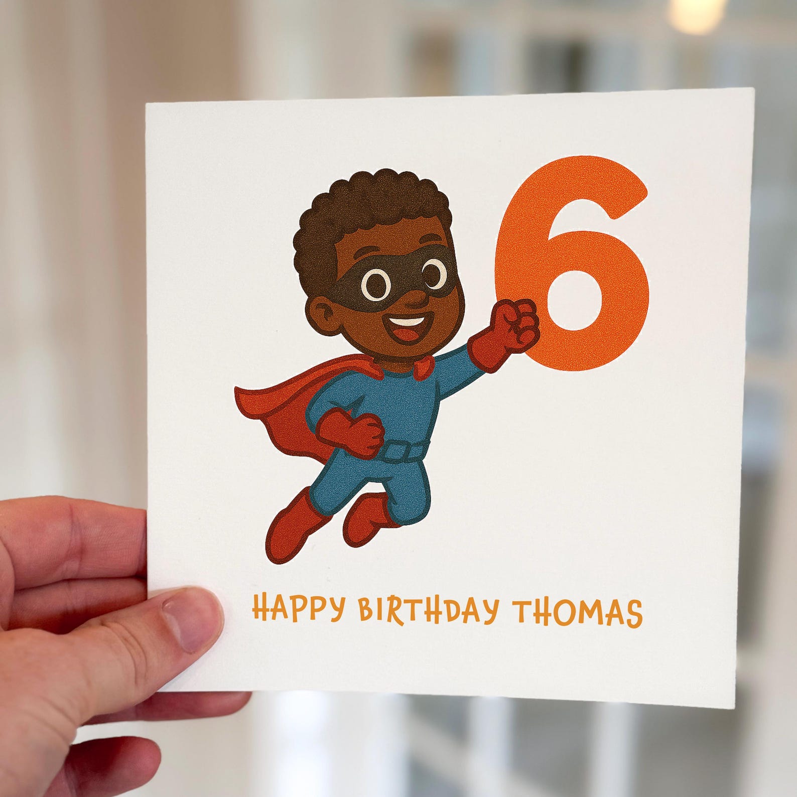 Kids birthday card with a cartoon superhero flying while holding a bright orange number six, printed on textured card.