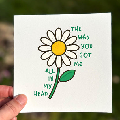 Love card featuring a white daisy with green text reading ‘The Way You Got Me All In My Head’.