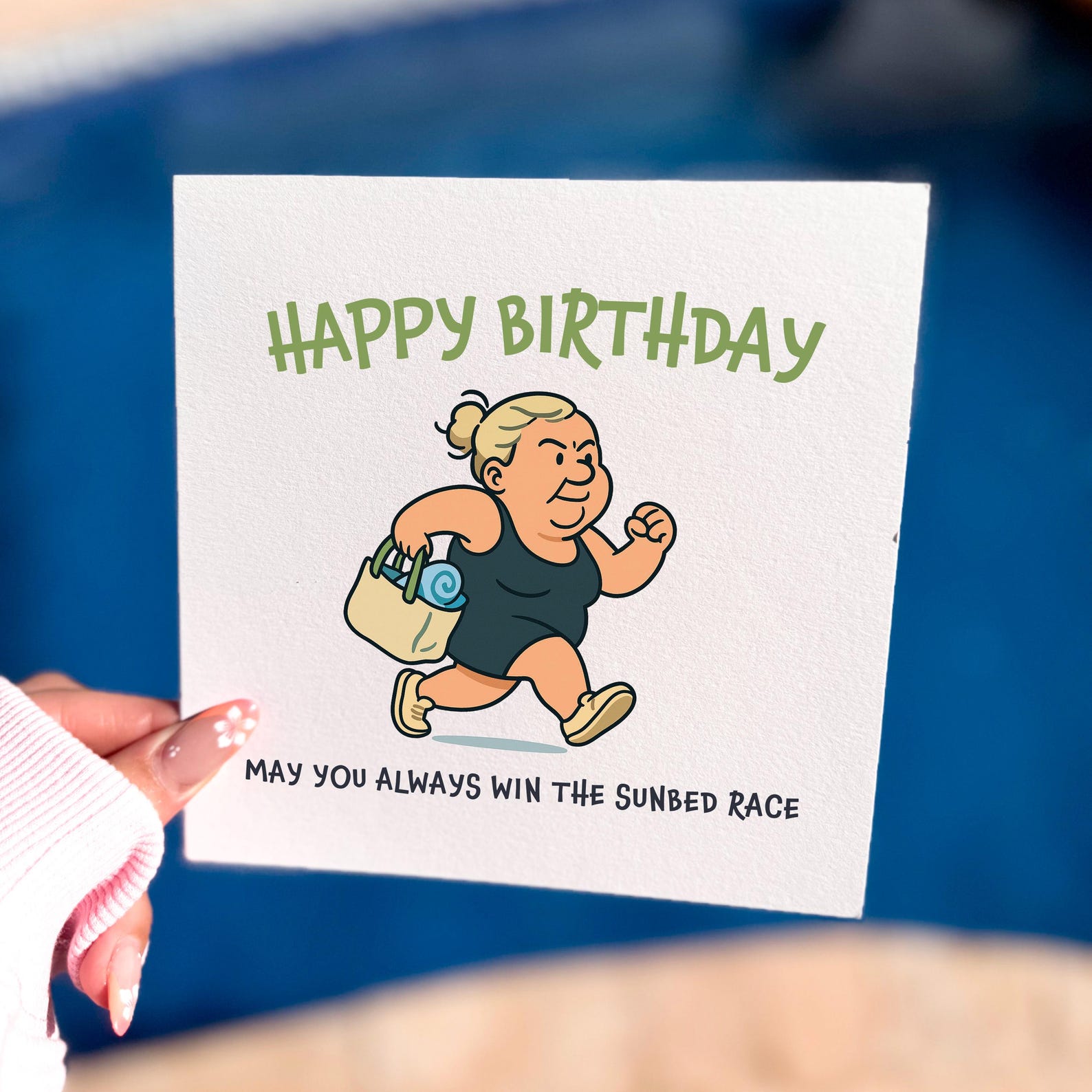 Funny cartoon birthday card showing a woman running with a towel and bag with the text ‘May you always win the sunbed race’.